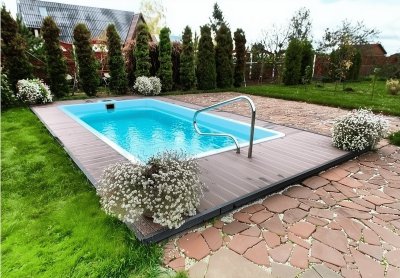 Композитный прямоугольный бассейн с террасной доской и металлическим поручнем на участке
